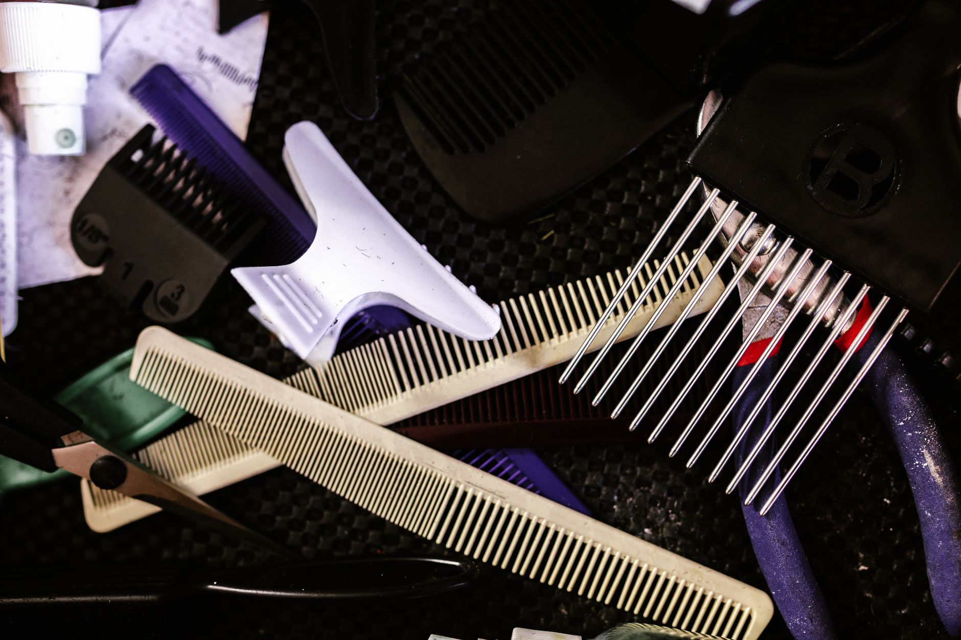 Collection of essential hairdressing tools including combs, clips, and scissors for salon use.