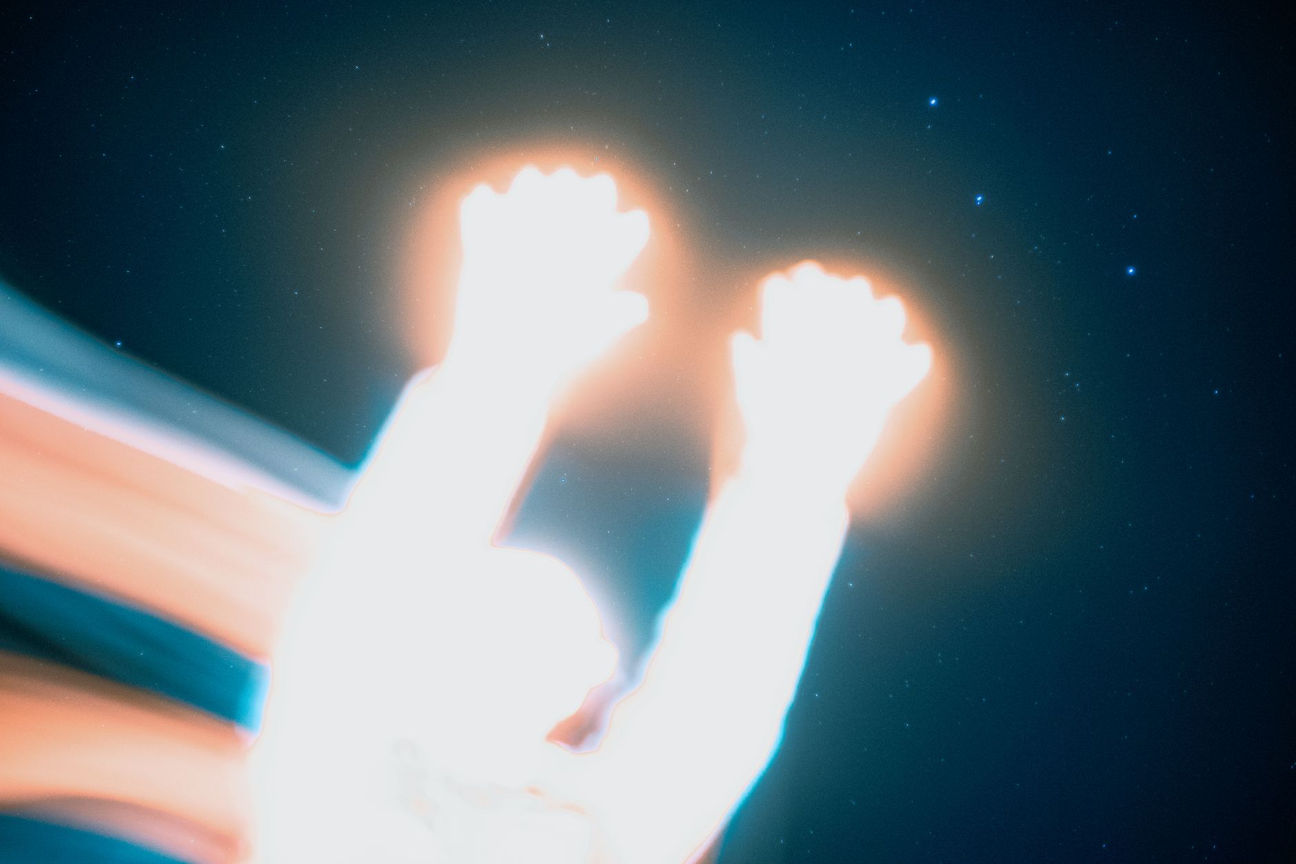 Creative long exposure shot featuring abstract light painting and a starry sky backdrop.